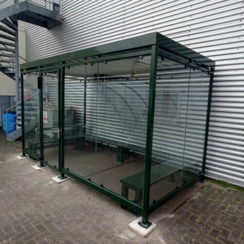Rookoverkapping Myla 215 Afgebeeld een grote rookoverkapping 8 x 2 meter in ral 7016. Voor optimaal comfort is model Myla uit te breiden met FSC-houten zitbanken of banken in RAL-kleur, eventueel gecombineerd met een stevige Cubix RVS-asbak.
